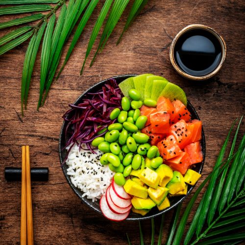 Poke bowl for balanced diet with salmon, avocado, radish, cabbage, beans, sesame and rice