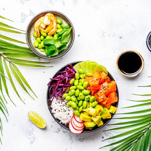 Poke bowl for balanced nutrition with salmon, avocado, radish, cabbage, edamame beans and rice
